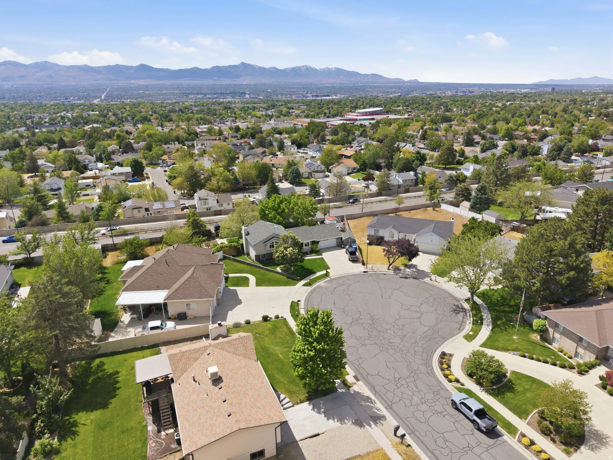 Cul-de-sac street with curved sidewalks, mature trees, and landscaping