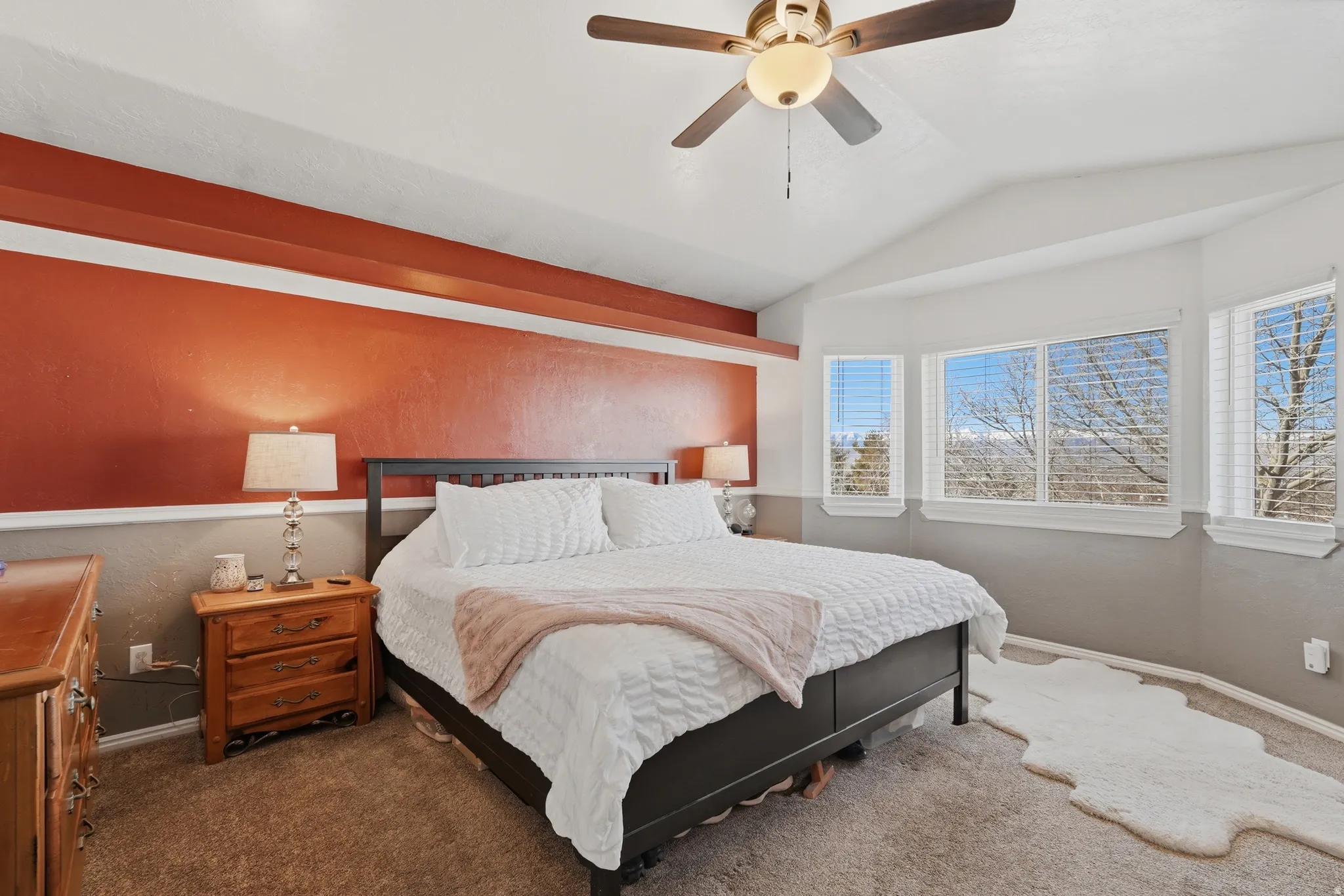 Bedroom featuring carpet, vaulted ceiling, and ceiling fan
