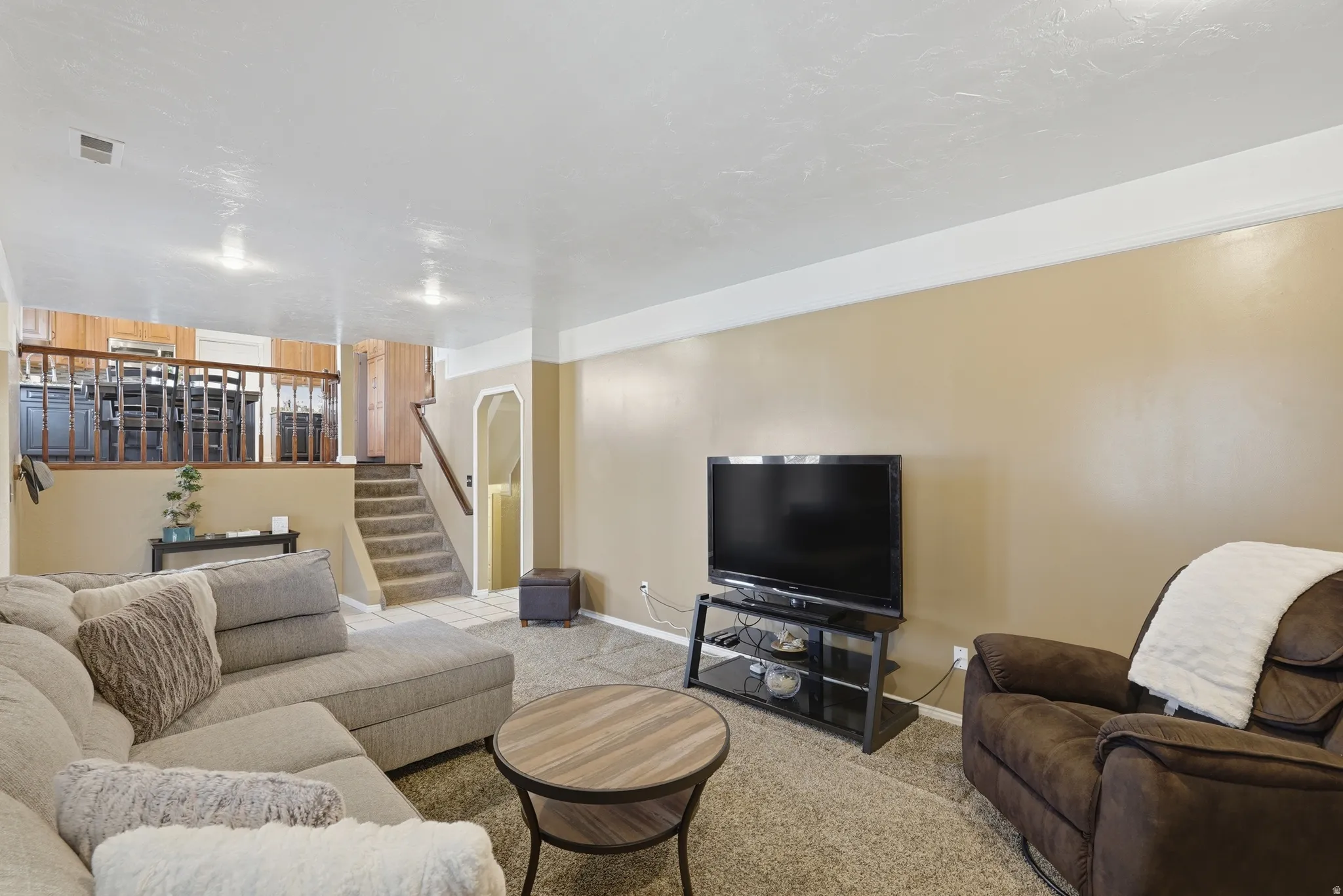 Living area with light carpet and arched walkways