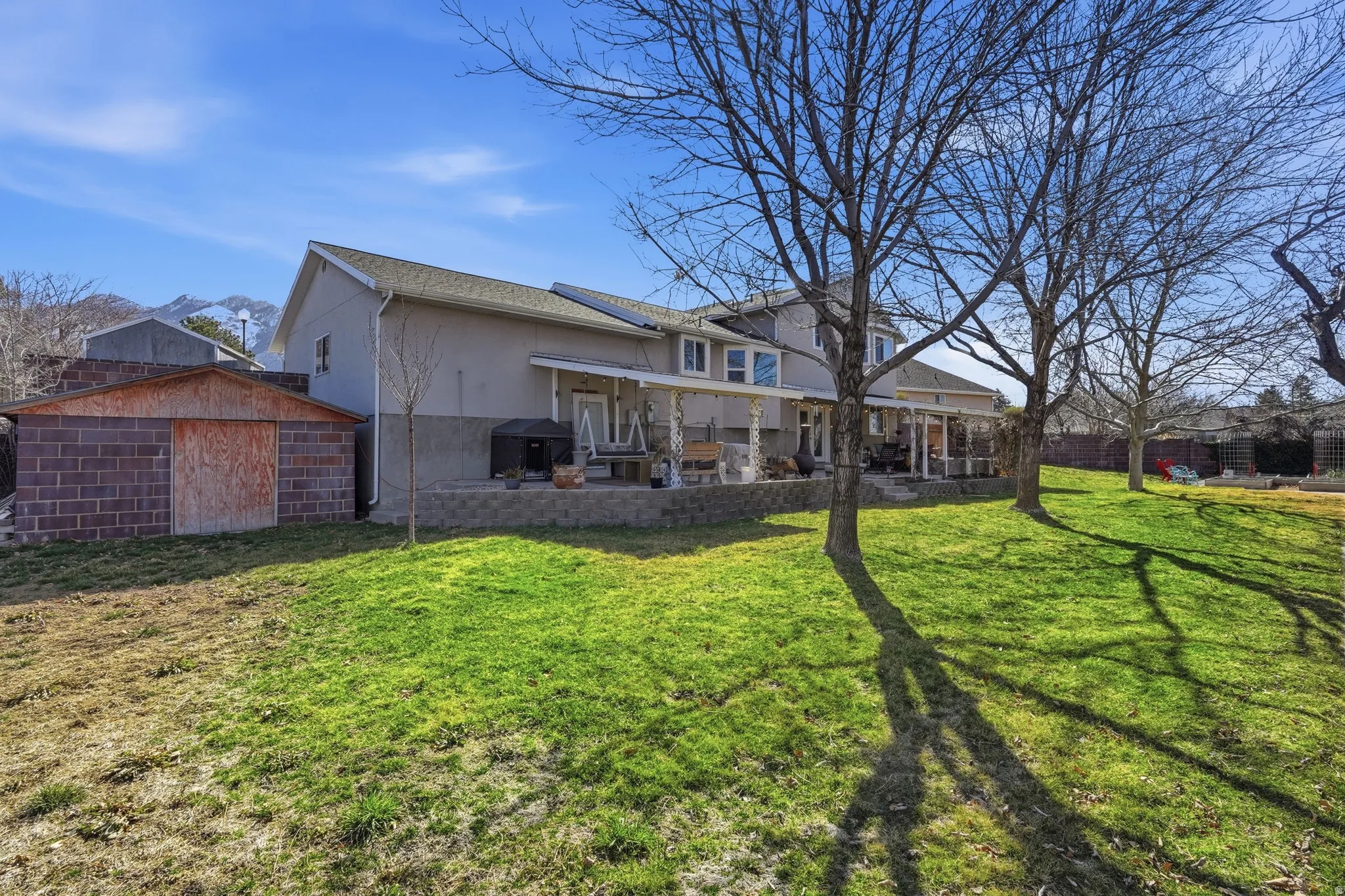 Back of house featuring a patio, stucco siding, and an outbuilding