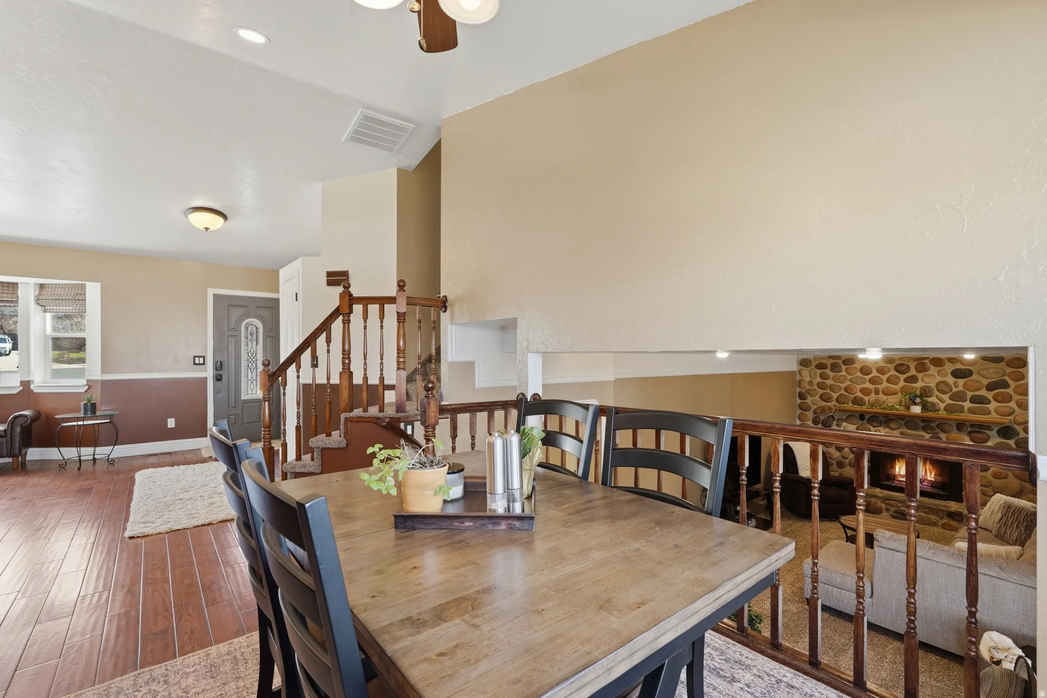 Dining room featuring a fireplace, wood finished floors, and a ceiling fan