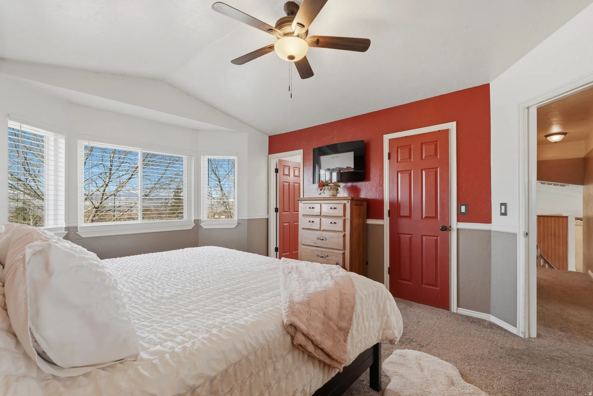 Carpeted bedroom with lofted ceiling and a ceiling fan