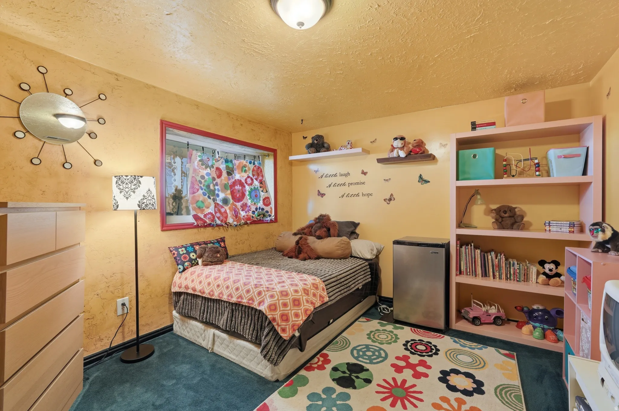 Bedroom featuring carpet, freestanding refrigerator, and a textured ceiling