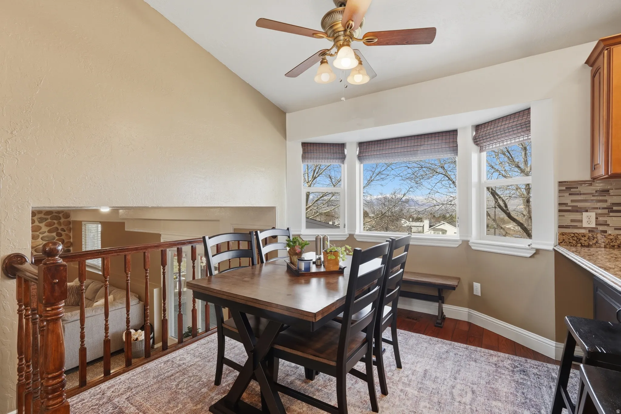 Dining space featuring wood finished floors, plenty of natural light, vaulted ceiling, and ceiling fan