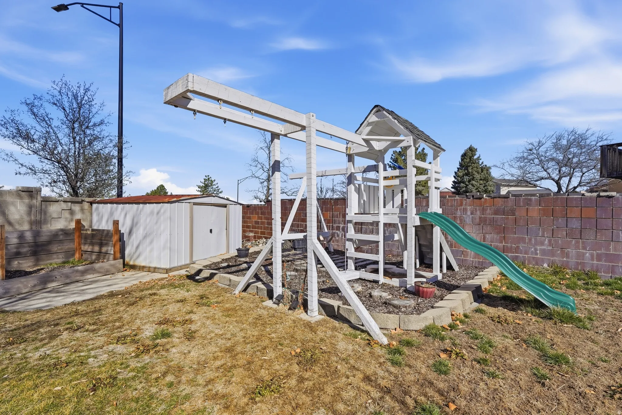 View of play area with a storage shed, a fenced backyard, and a patio area