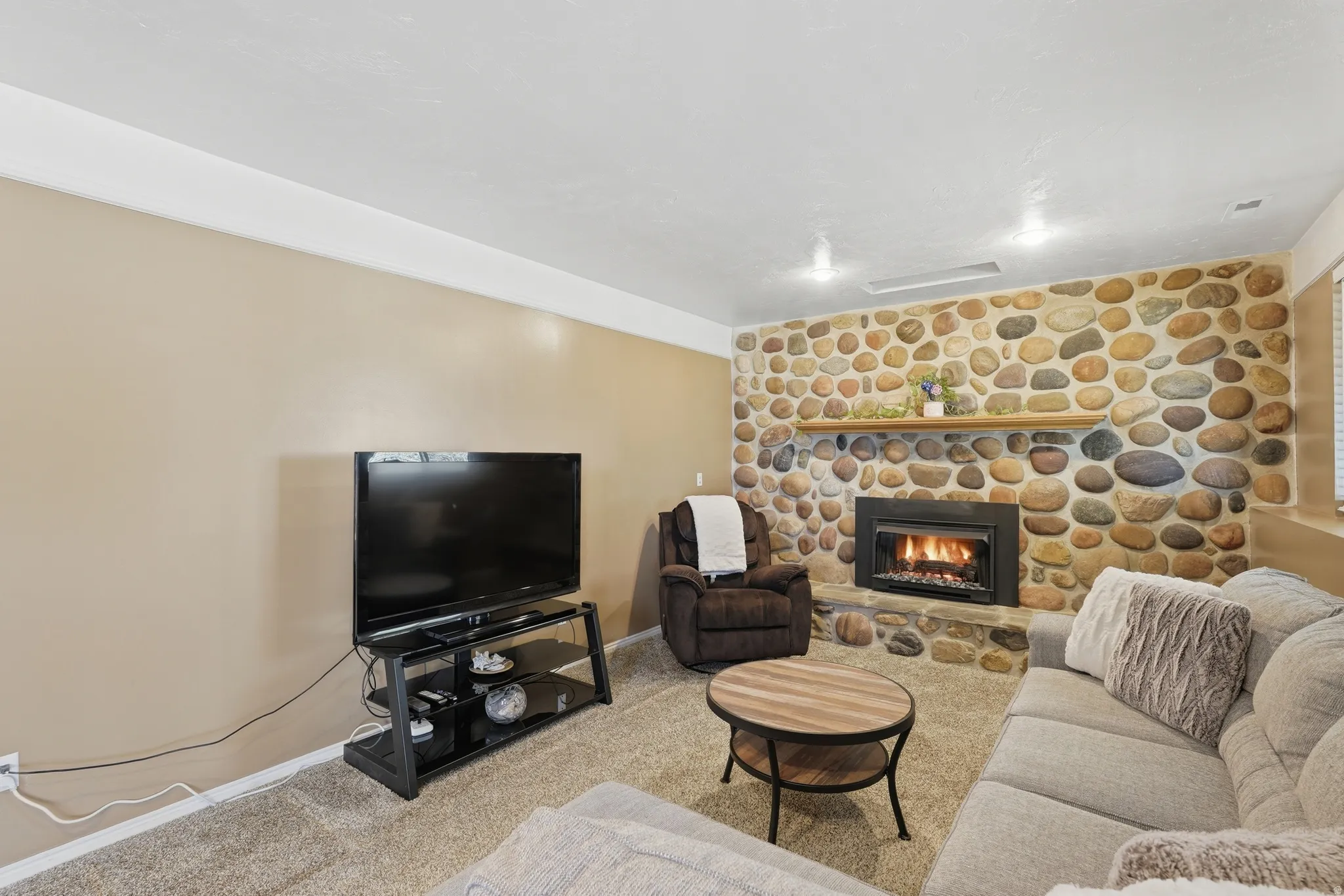 Living area featuring light carpet and a fireplace