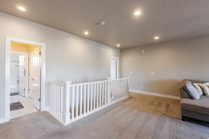 Living area with light colored carpet and recessed lighting