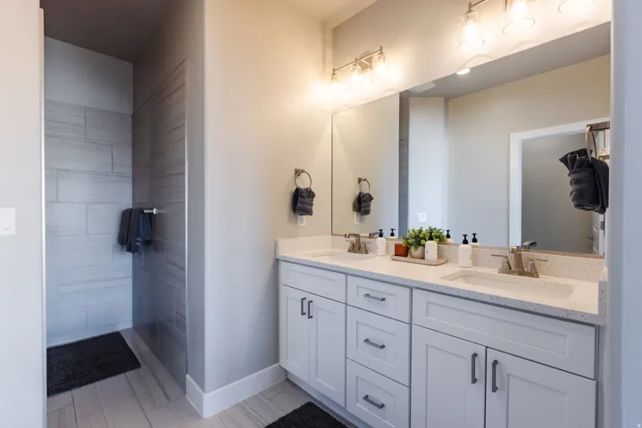 Full bathroom featuring double vanity and baseboards
