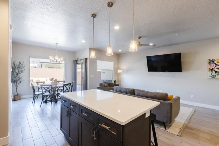 Kitchen with a center island, light stone counters, a kitchen breakfast bar, open floor plan, and a textured ceiling