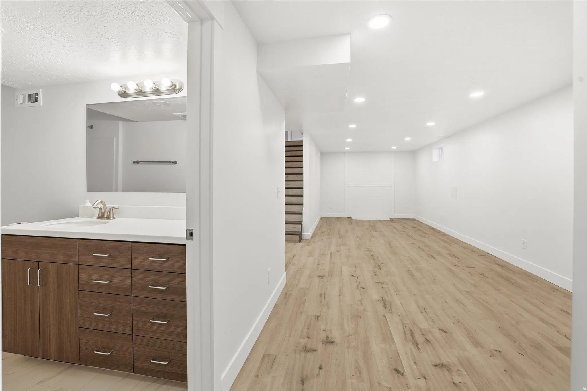 Basement ADU Bathroom featuring vanity and light wood-style floors