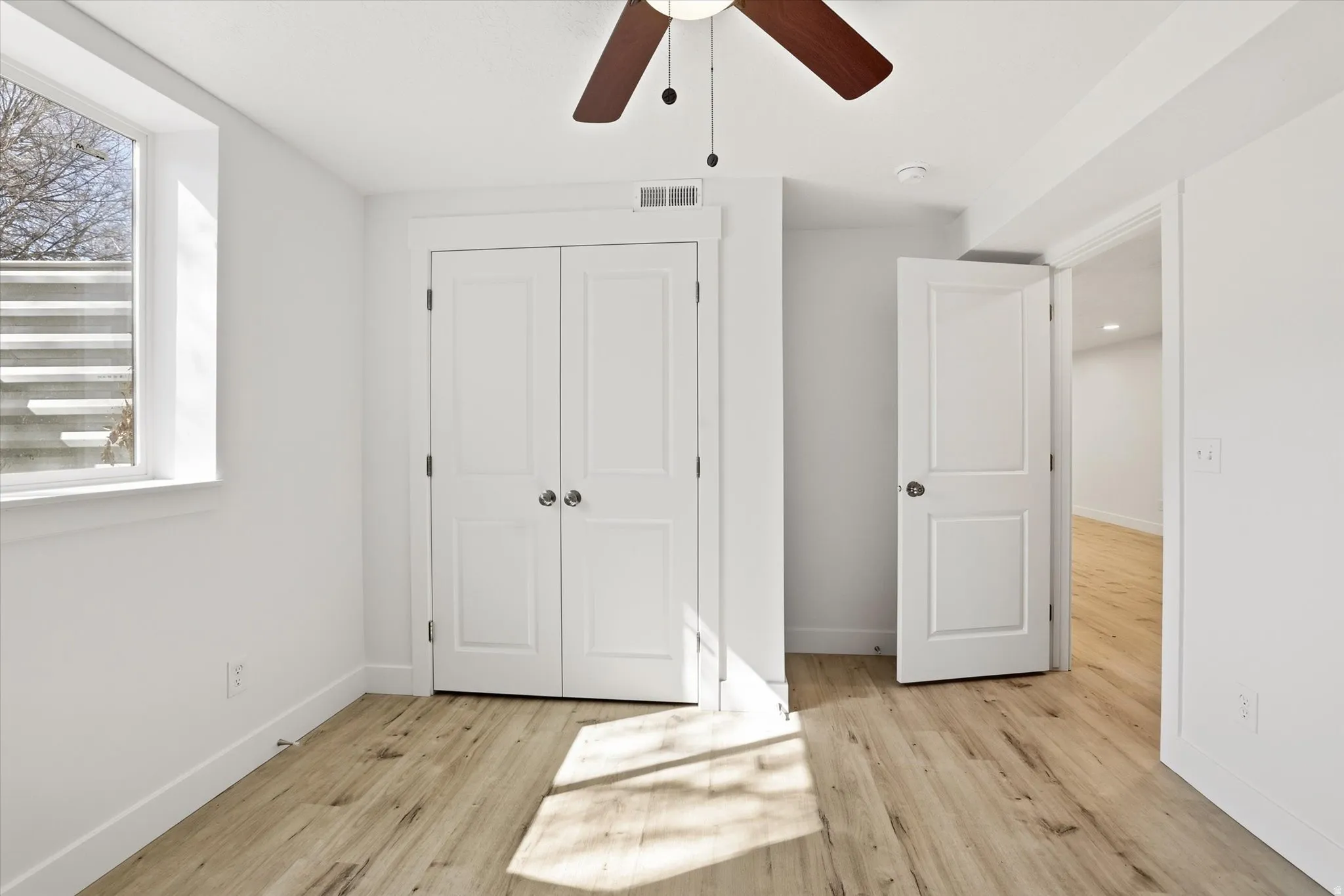 Unfurnished bedroom with light wood-style flooring, a closet, and ceiling fan