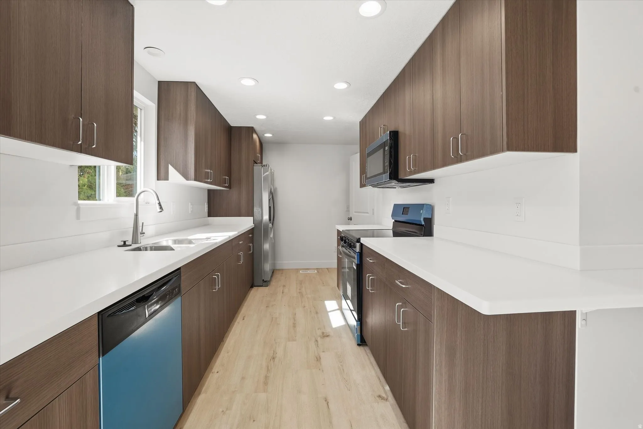Kitchen with stainless steel appliances, light wood-style floors, modern cabinets, and recessed lighting