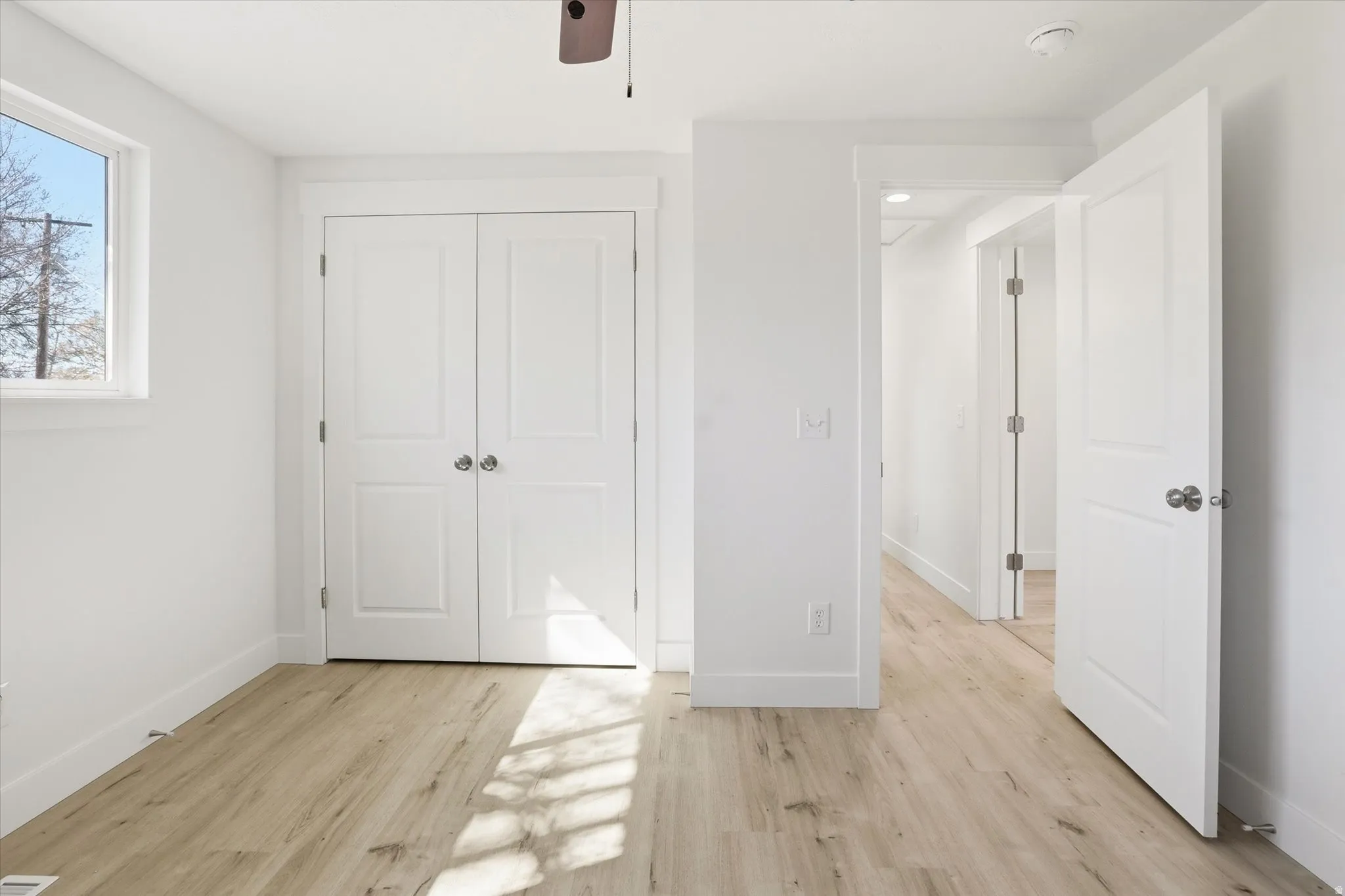 Unfurnished bedroom with light wood-type flooring, a closet, and ceiling fan