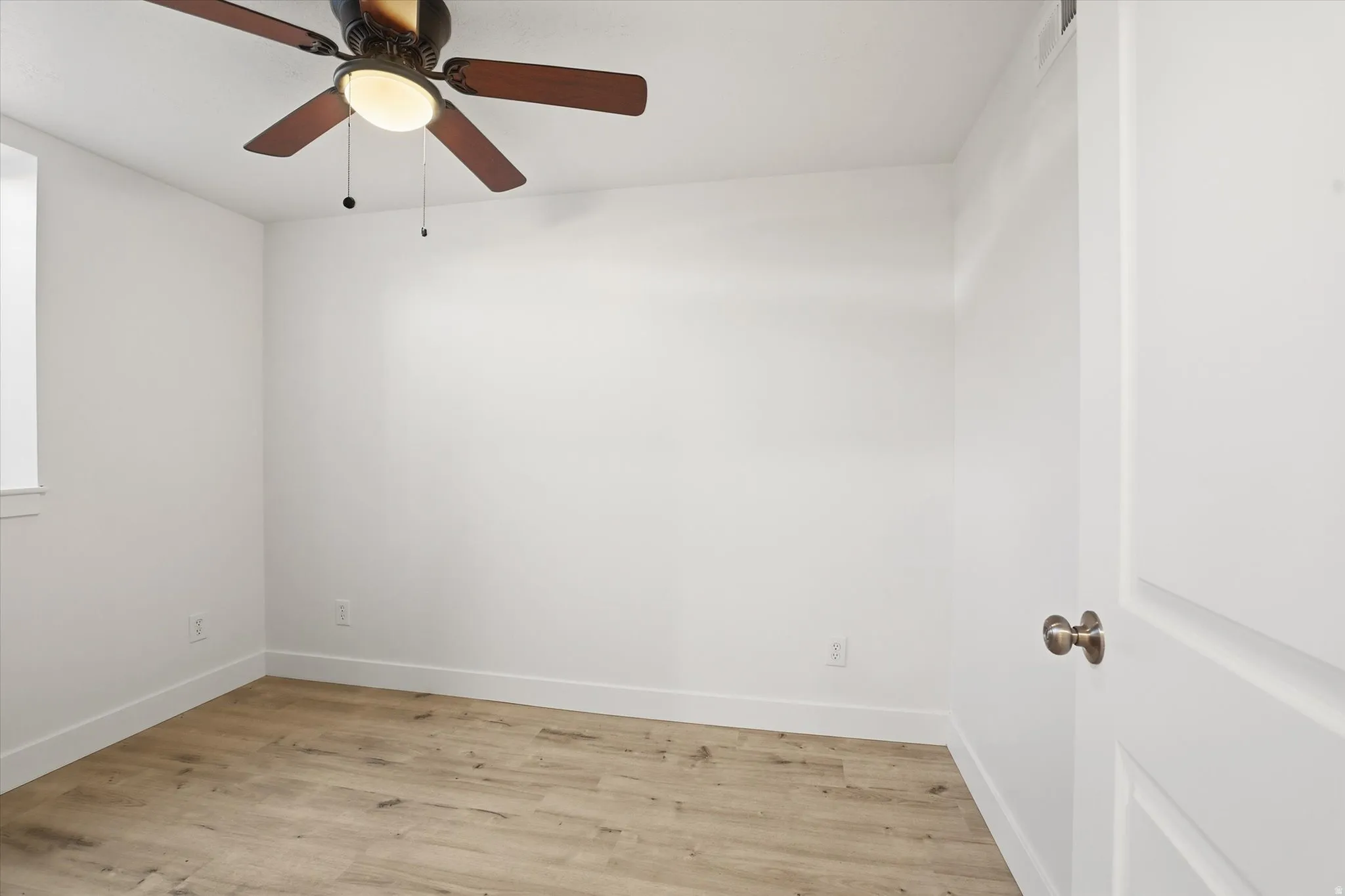 Spare room featuring light wood-style floors and ceiling fan
