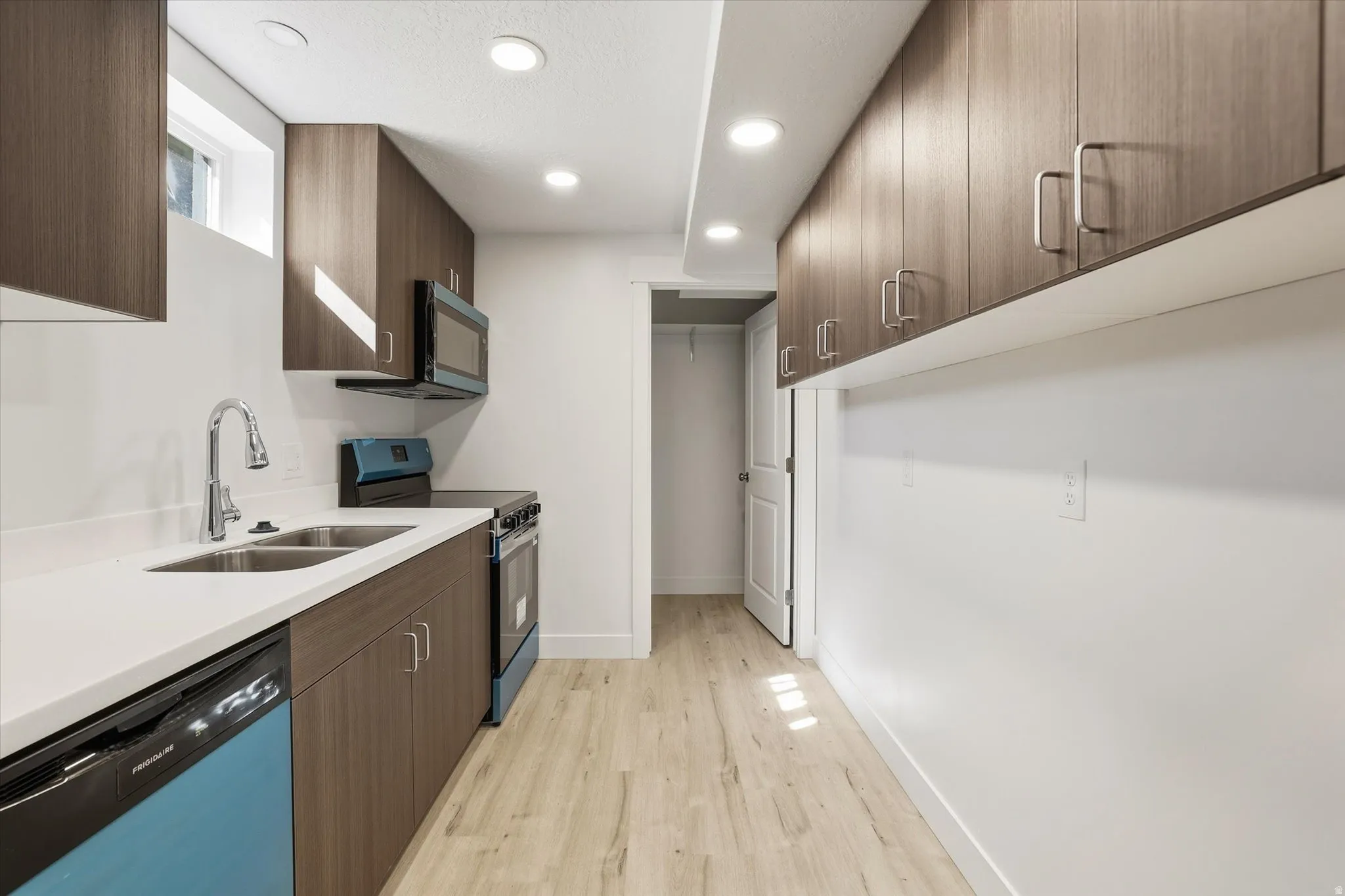 Kitchen featuring modern cabinets, stainless steel electric stove, dishwasher, recessed lighting, and light wood-type flooring
