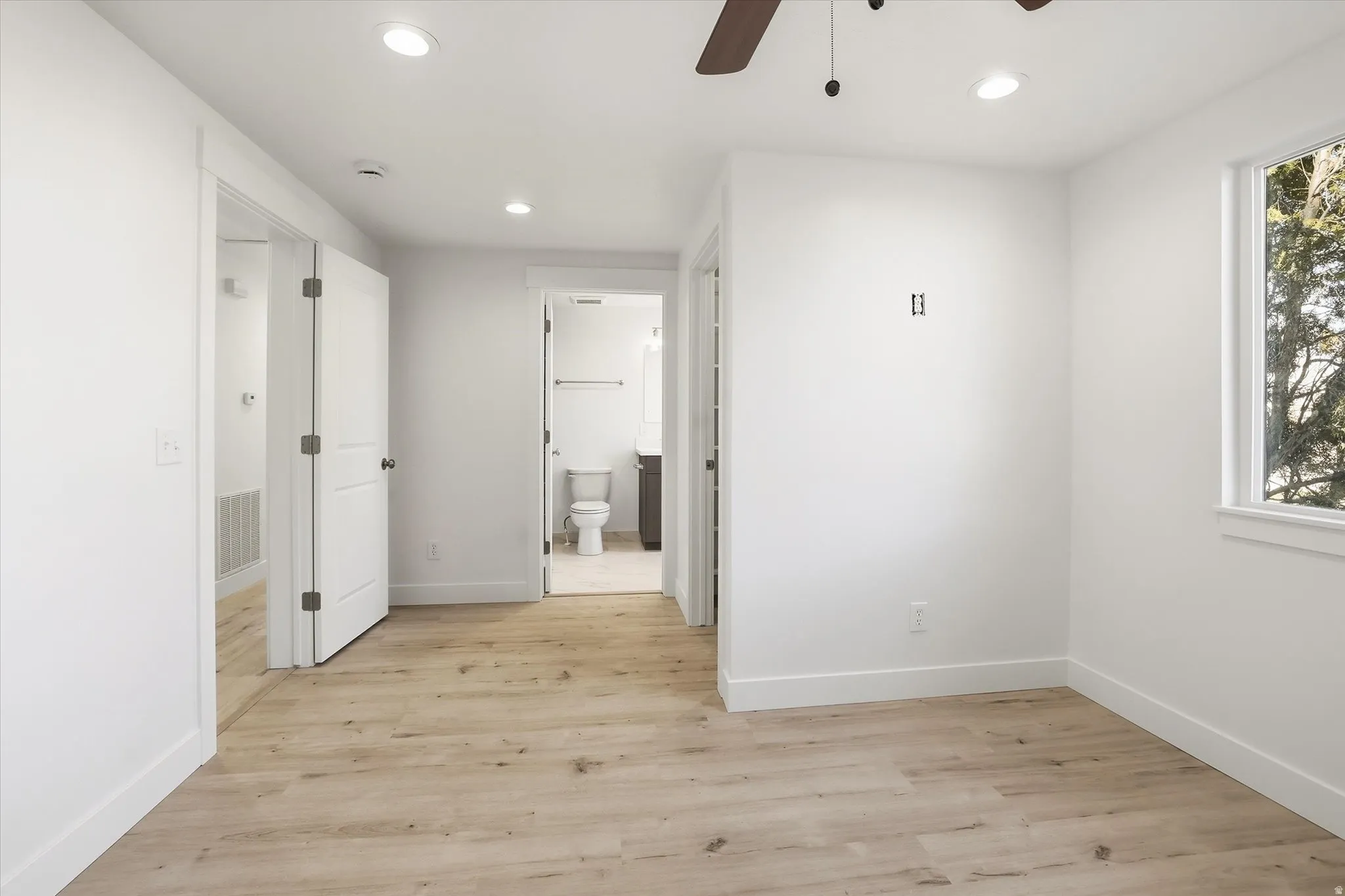 Primary Suite Unfurnished bedroom with light wood-style floors, recessed lighting, a ceiling fan, and ensuite bathroom