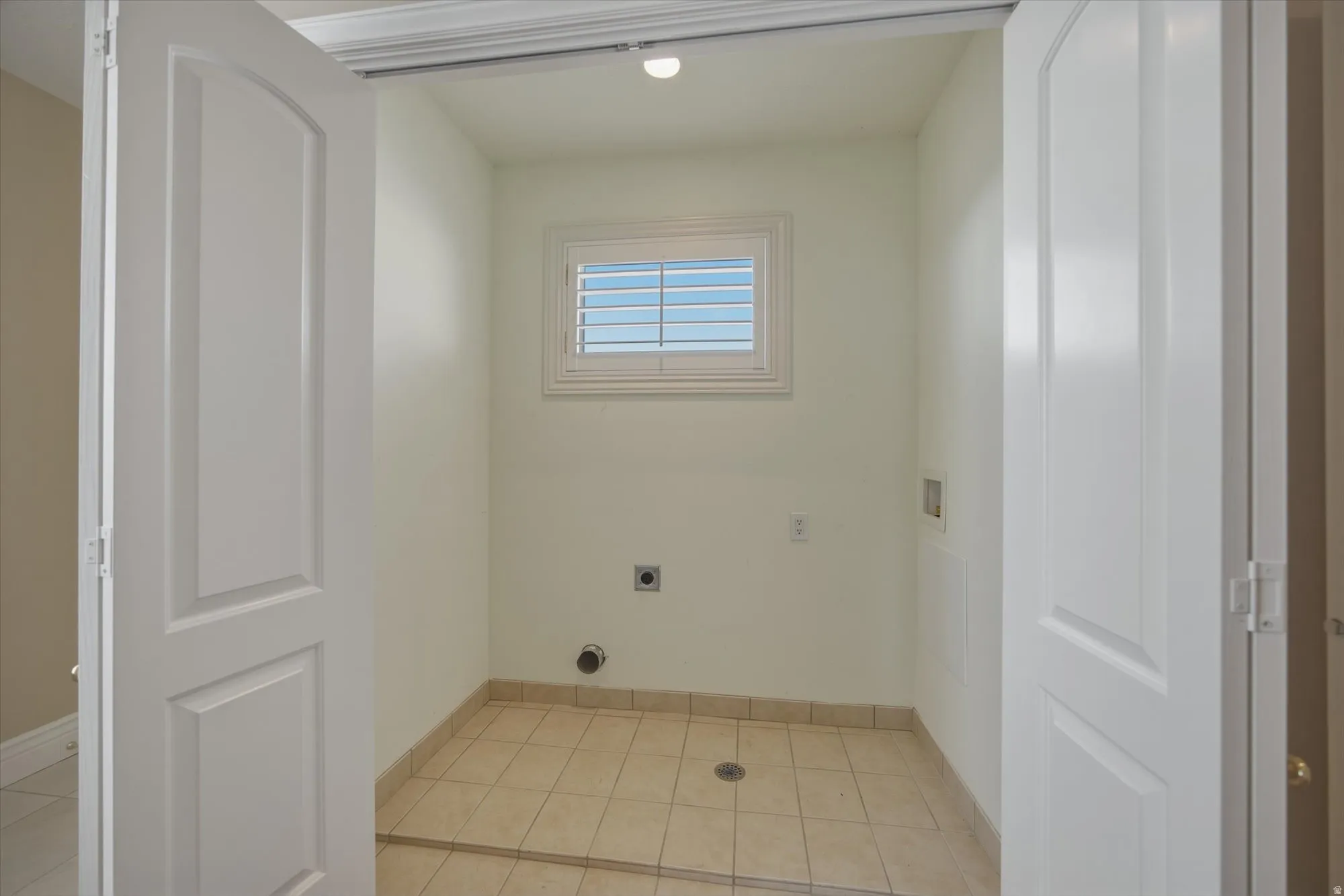 Laundry area featuring hookup for a washing machine, hookup for an electric dryer, and light tile patterned floors