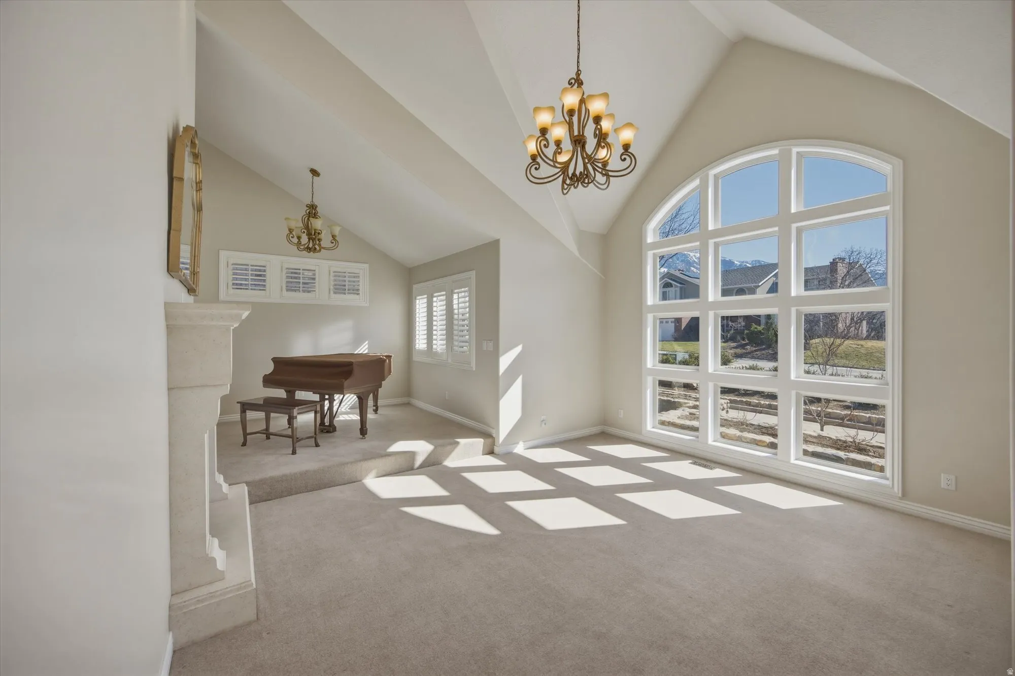 Living area with hanging lights, light carpet, and lofted ceiling