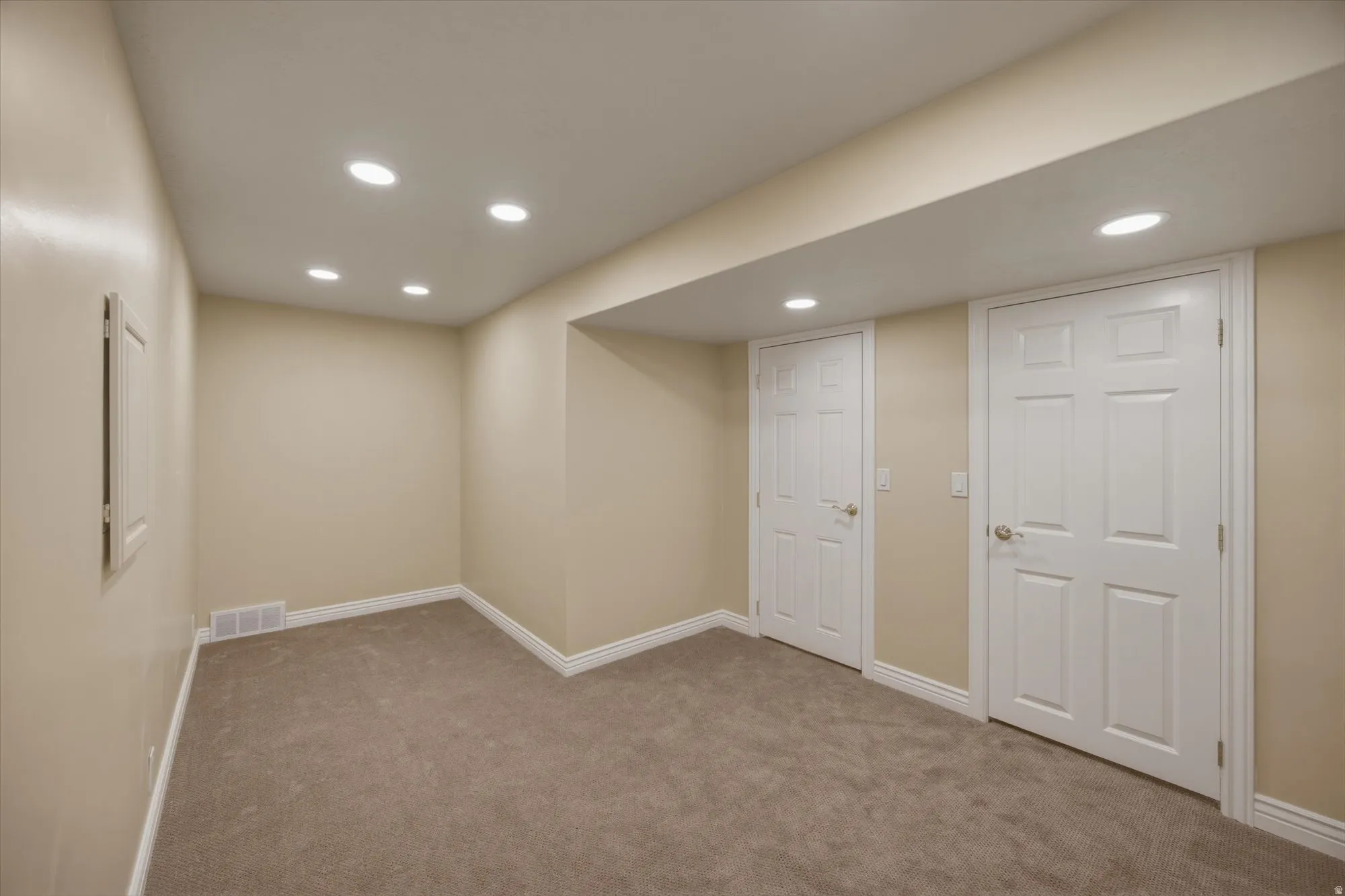 Finished basement with recessed lighting and carpet