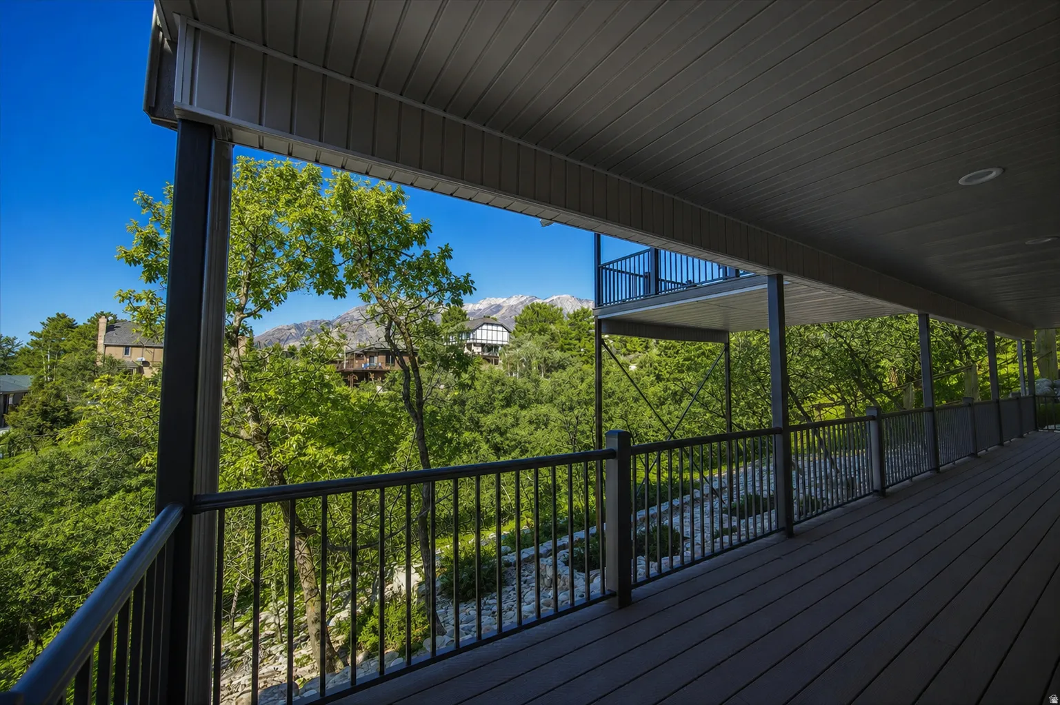 Expansive covered deck featuring composite decking and a black metal railing system