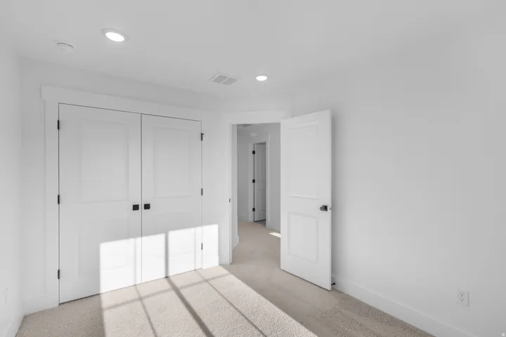 Unfurnished bedroom with light colored carpet, recessed lighting, and a closet