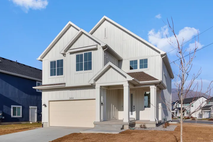 Modern farmhouse with a garage, driveway, roof with shingles, and board and batten siding