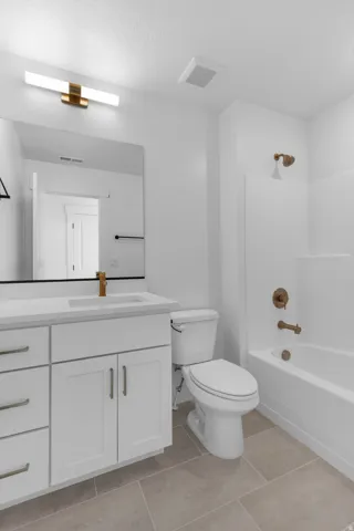 Full bathroom with vanity, shower / bathtub combination, and light tile patterned flooring