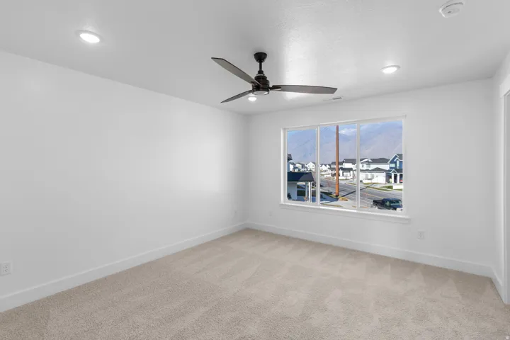 Spare room with light carpet and ceiling fan