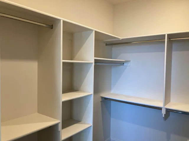 Custom closet system with multiple shelving units and integrated hanging rods