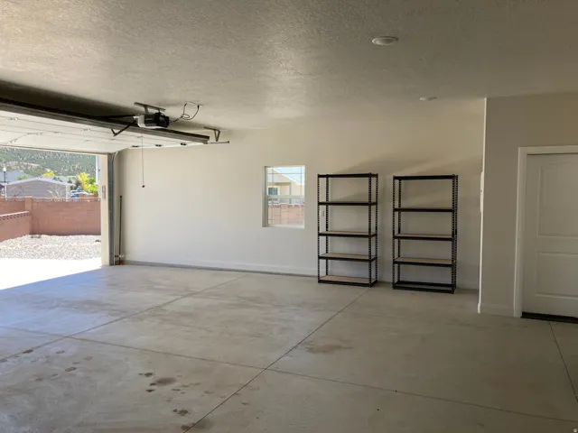 Spacious garage featuring a concrete floor, painted interior walls, and an overhead garage door opener