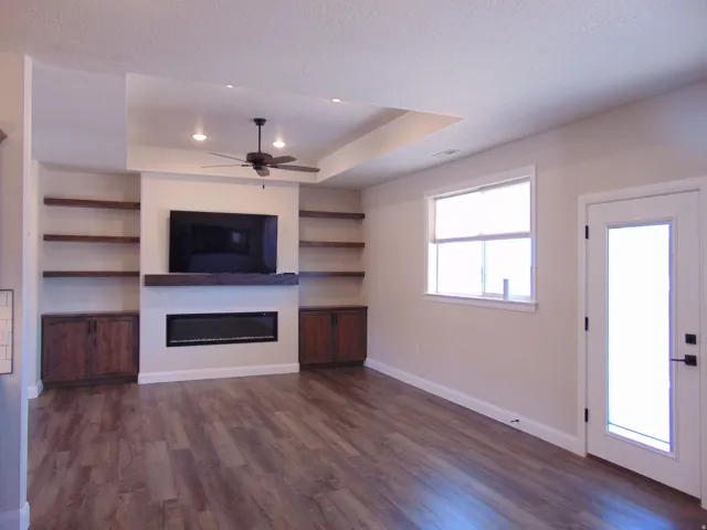 Living area featuring wood-finish flooring and a built-in entertainment center