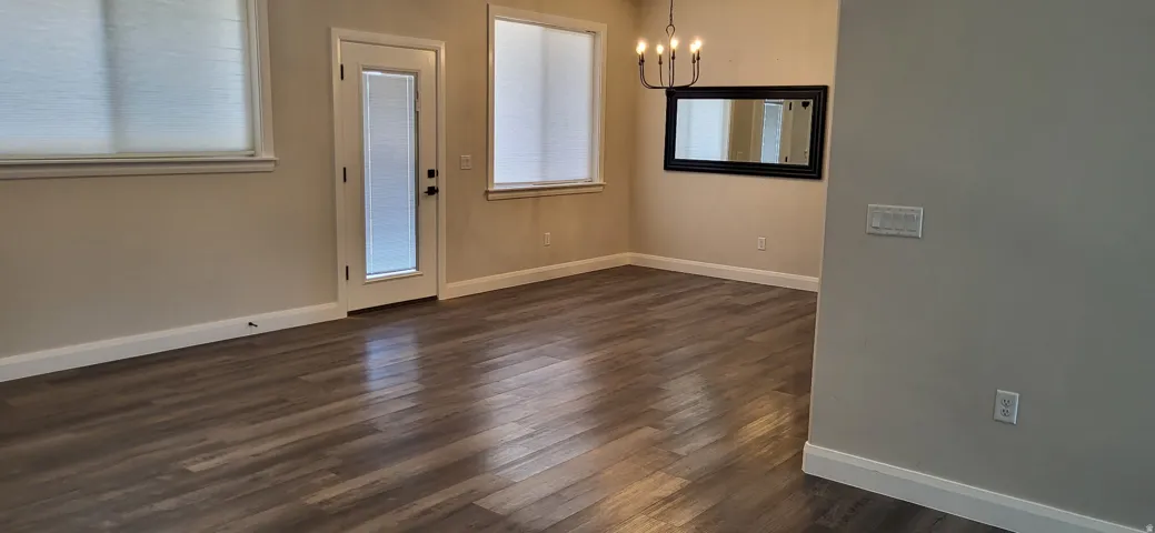 Wood-finish flooring, white trim, recessed lighting, and a modern chandelier