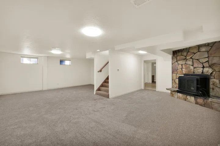 Basement with carpet, a fireplace, and a textured ceiling