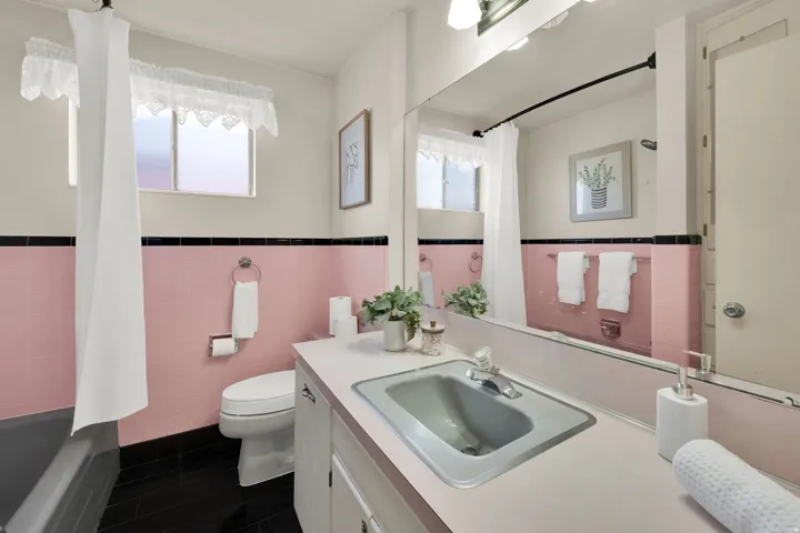 Full bathroom featuring vanity, tile walls, wainscoting, and shower / bath combo