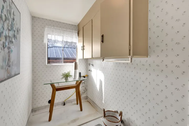 Laundry room featuring cabinet space and wallpapered walls