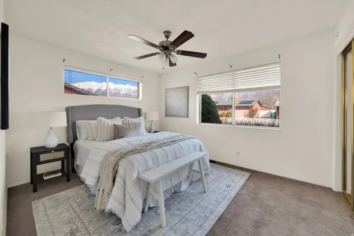 Bedroom featuring carpet flooring, multiple windows, and ceiling fan