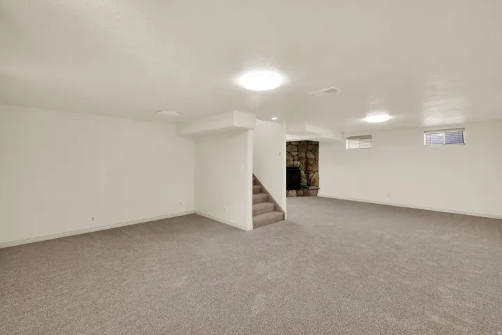 Basement featuring light carpet and a textured ceiling