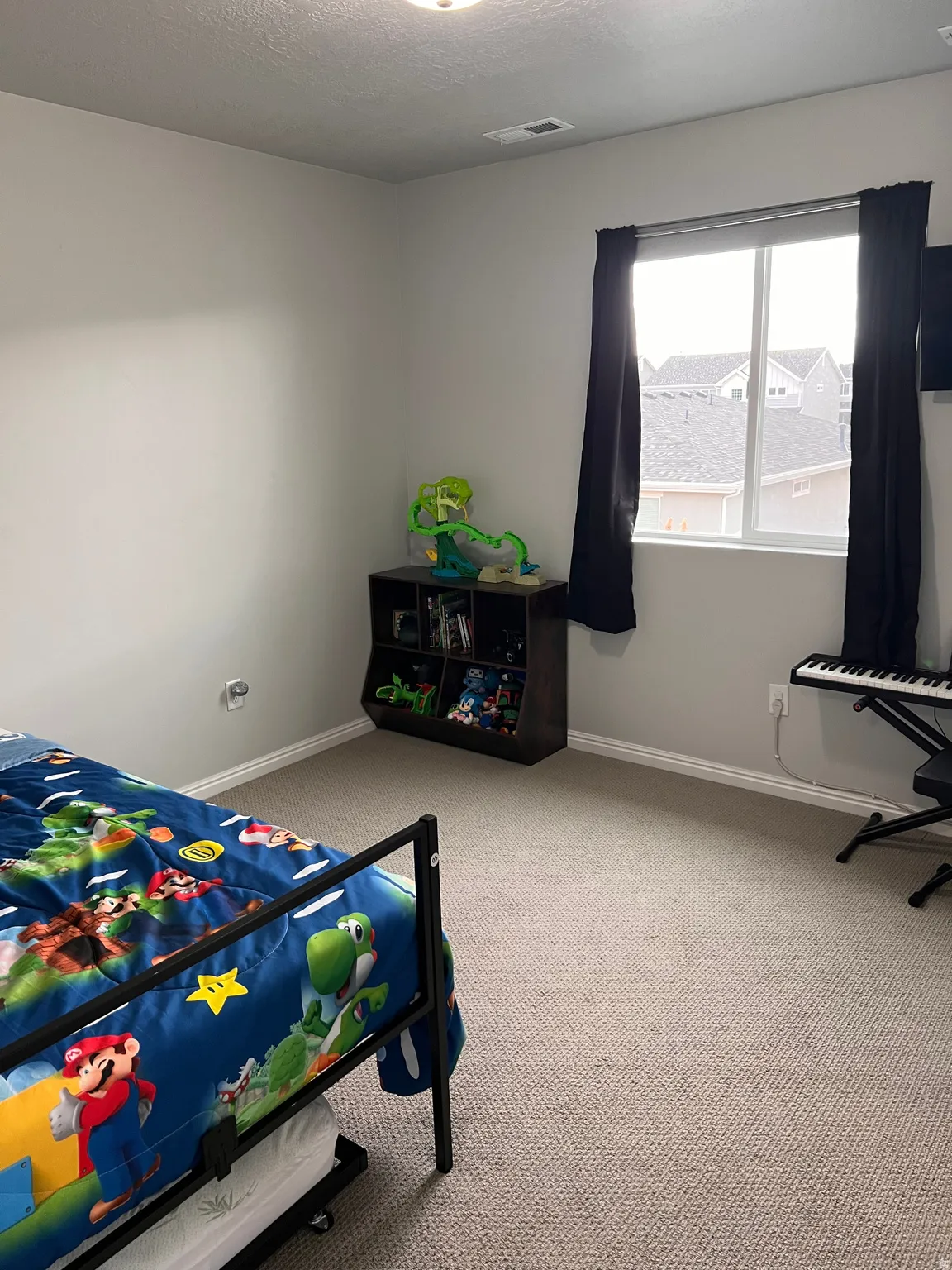 Bedroom with light carpet and a textured ceiling