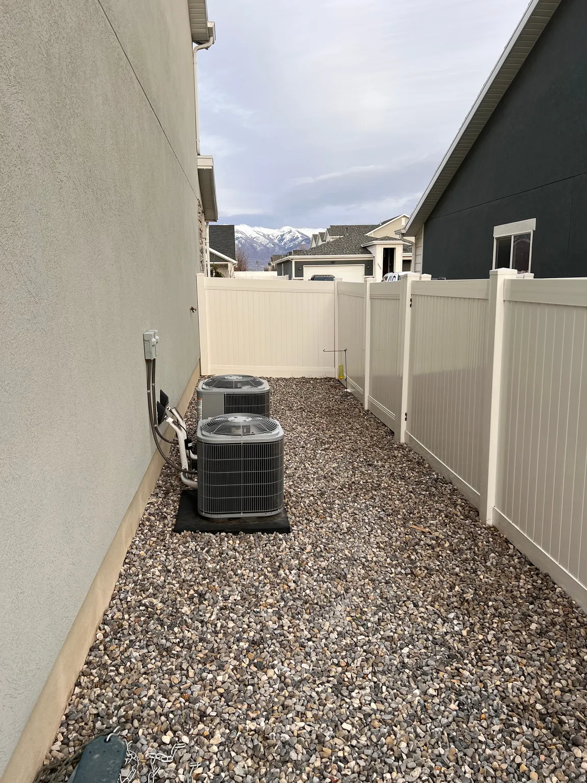 Fenced backyard with a mountain view featuring two a/c units