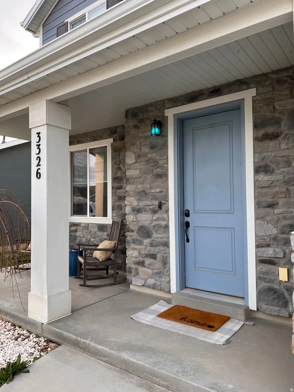 Property entrance featuring stone siding and a porch