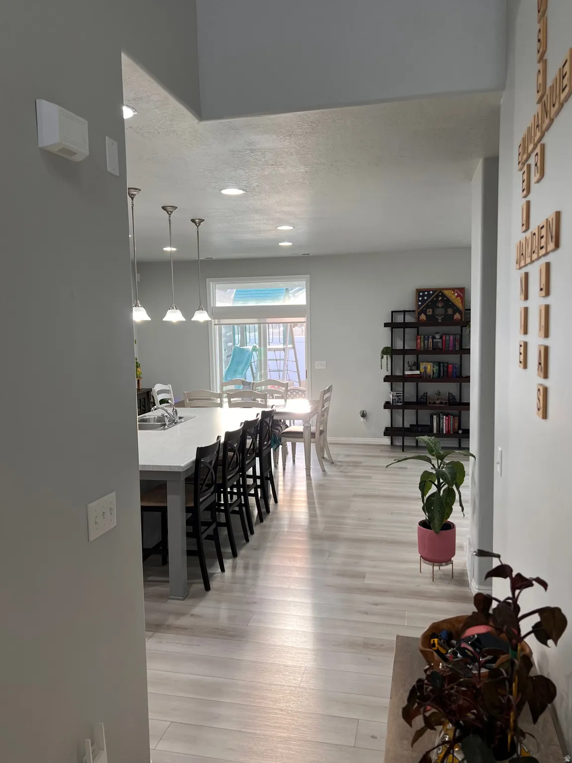 Dining space with light wood-type flooring, a textured ceiling, and recessed lighting