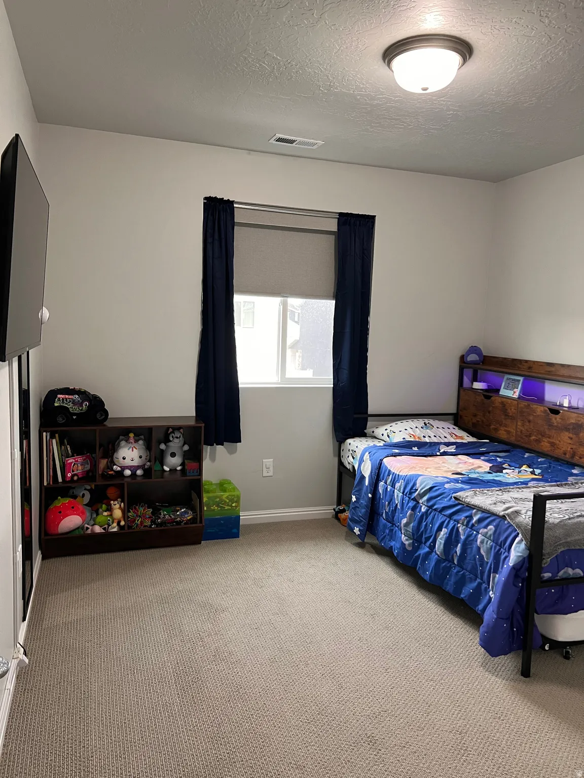 Bedroom featuring a textured ceiling and light carpet