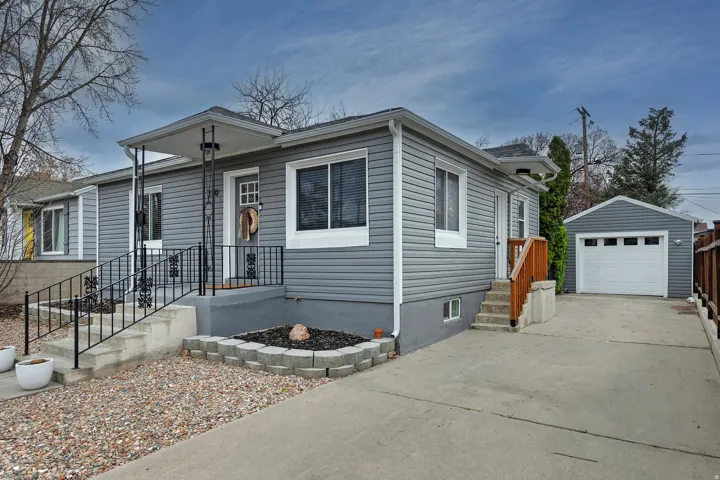 View of front of house featuring an outbuilding, a detached garage, and driveway