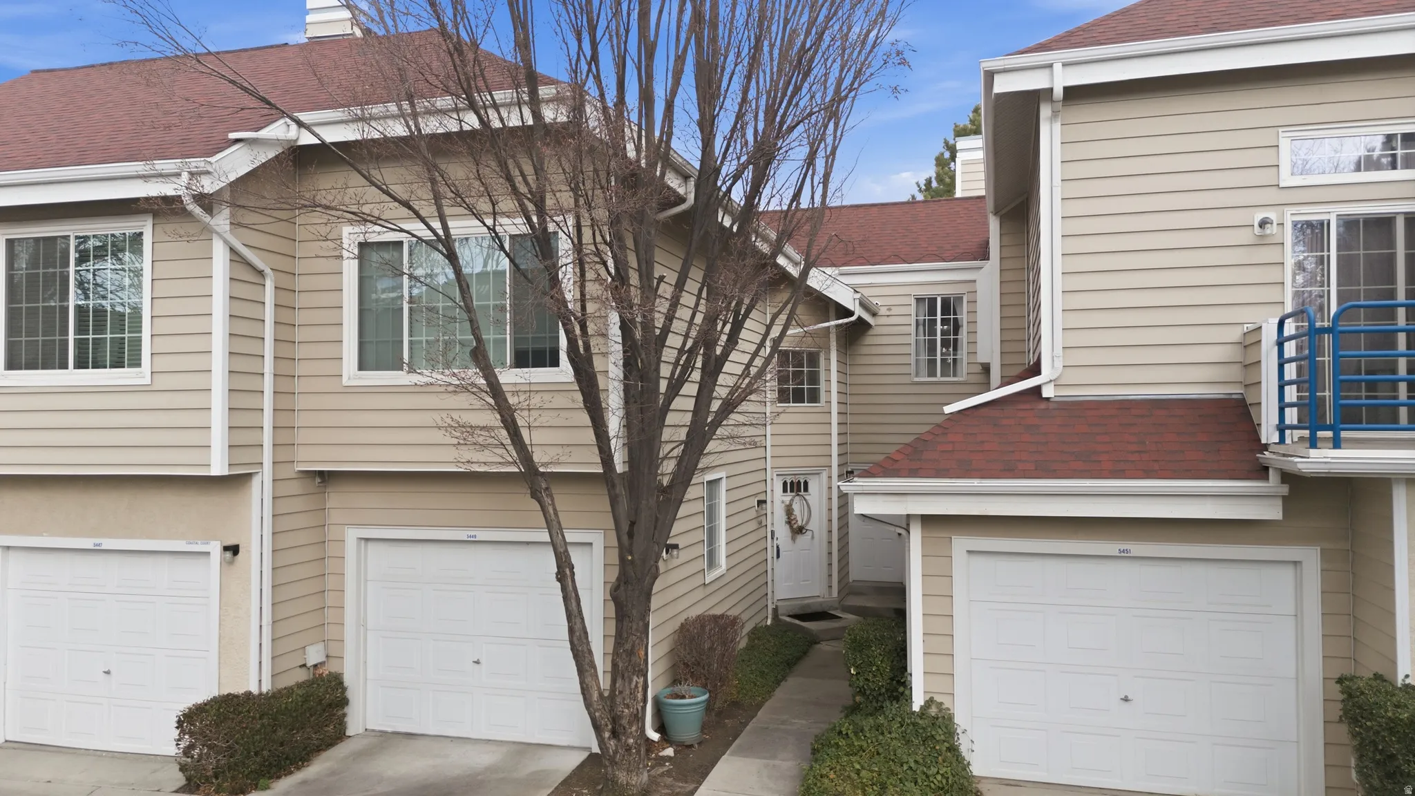 View of side of property featuring roof with shingles, an attached garage, and driveway