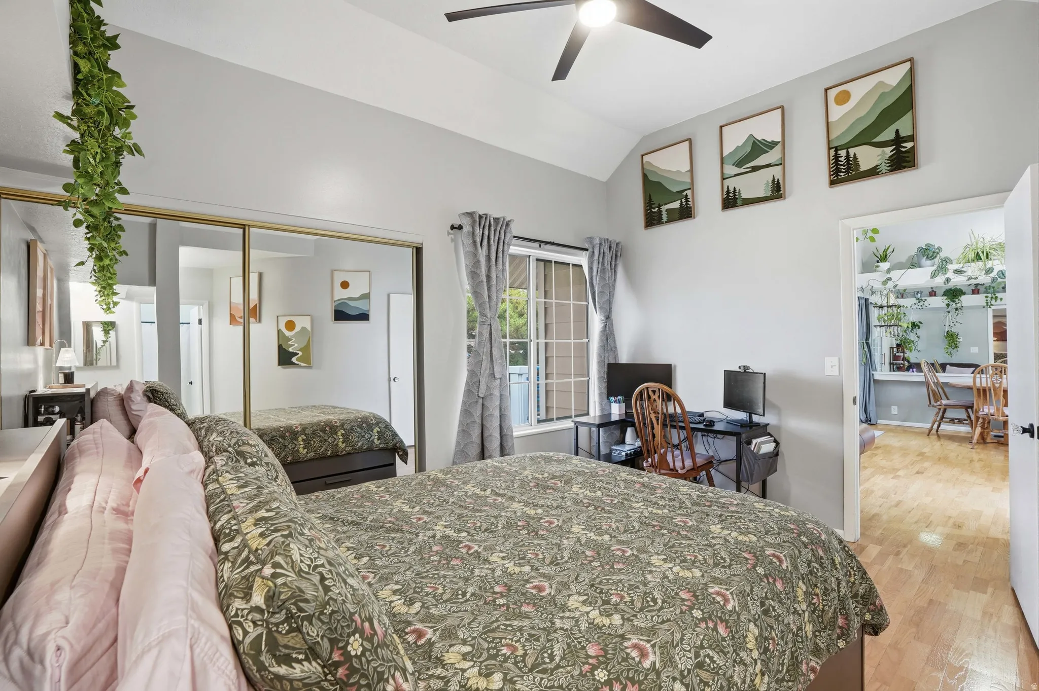 Bedroom with vaulted ceiling, light wood finished floors, a closet, an office area, and ceiling fan