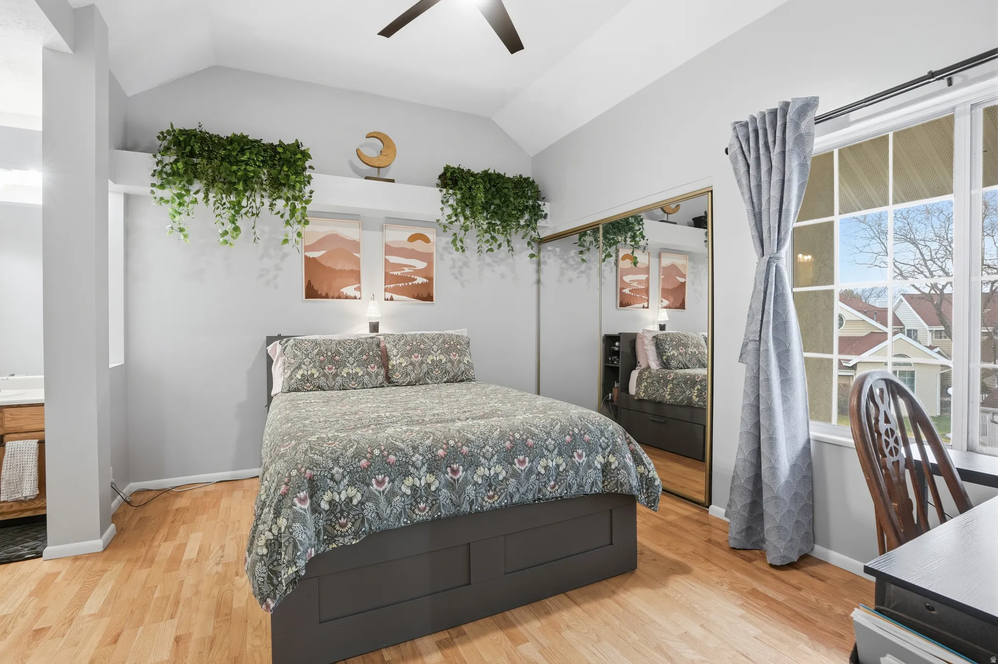 Bedroom with a closet, vaulted ceiling, light wood-style floors, and ceiling fan