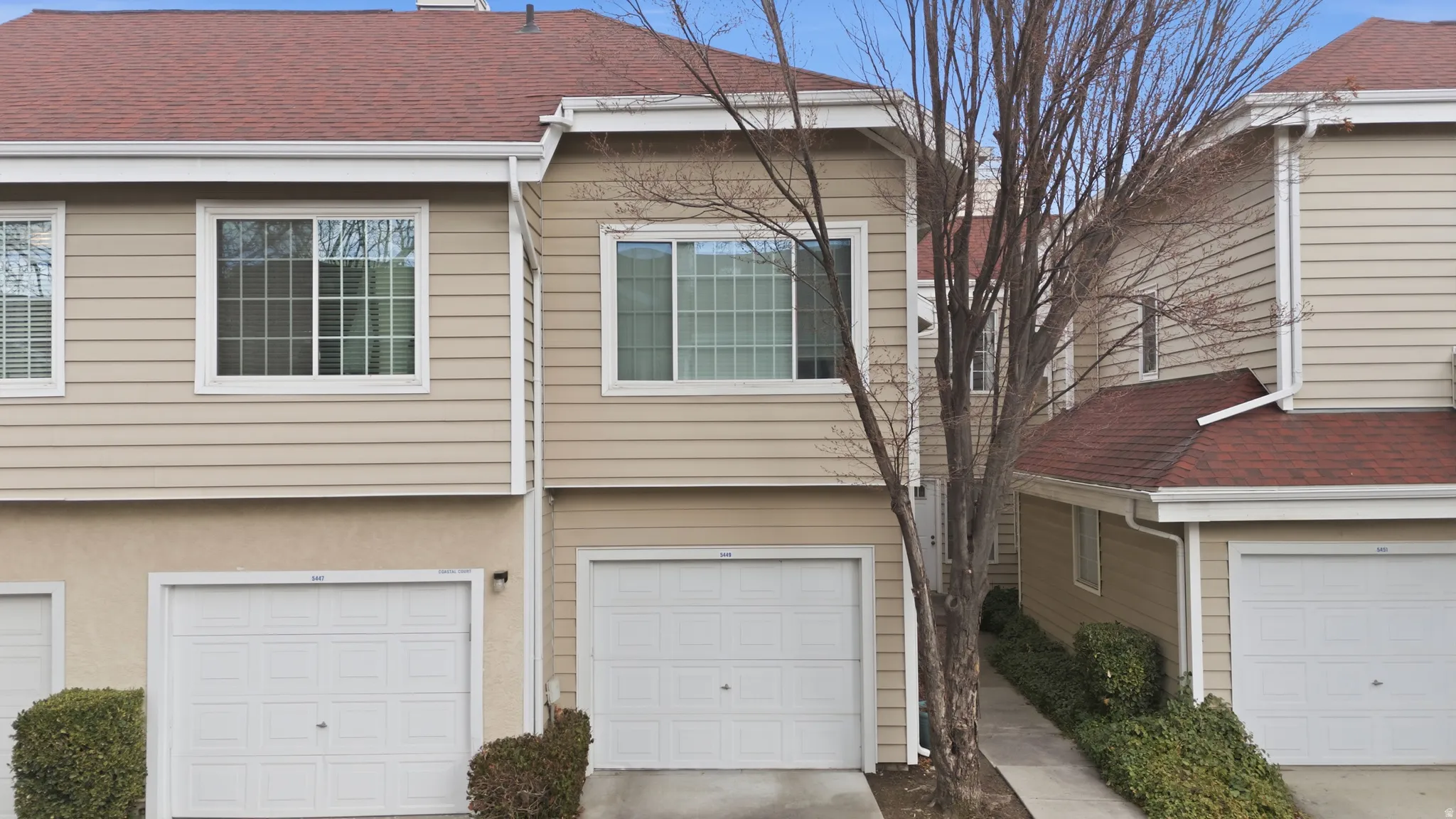 View of front of home featuring roof with shingles, stucco siding, a garage, and concrete driveway