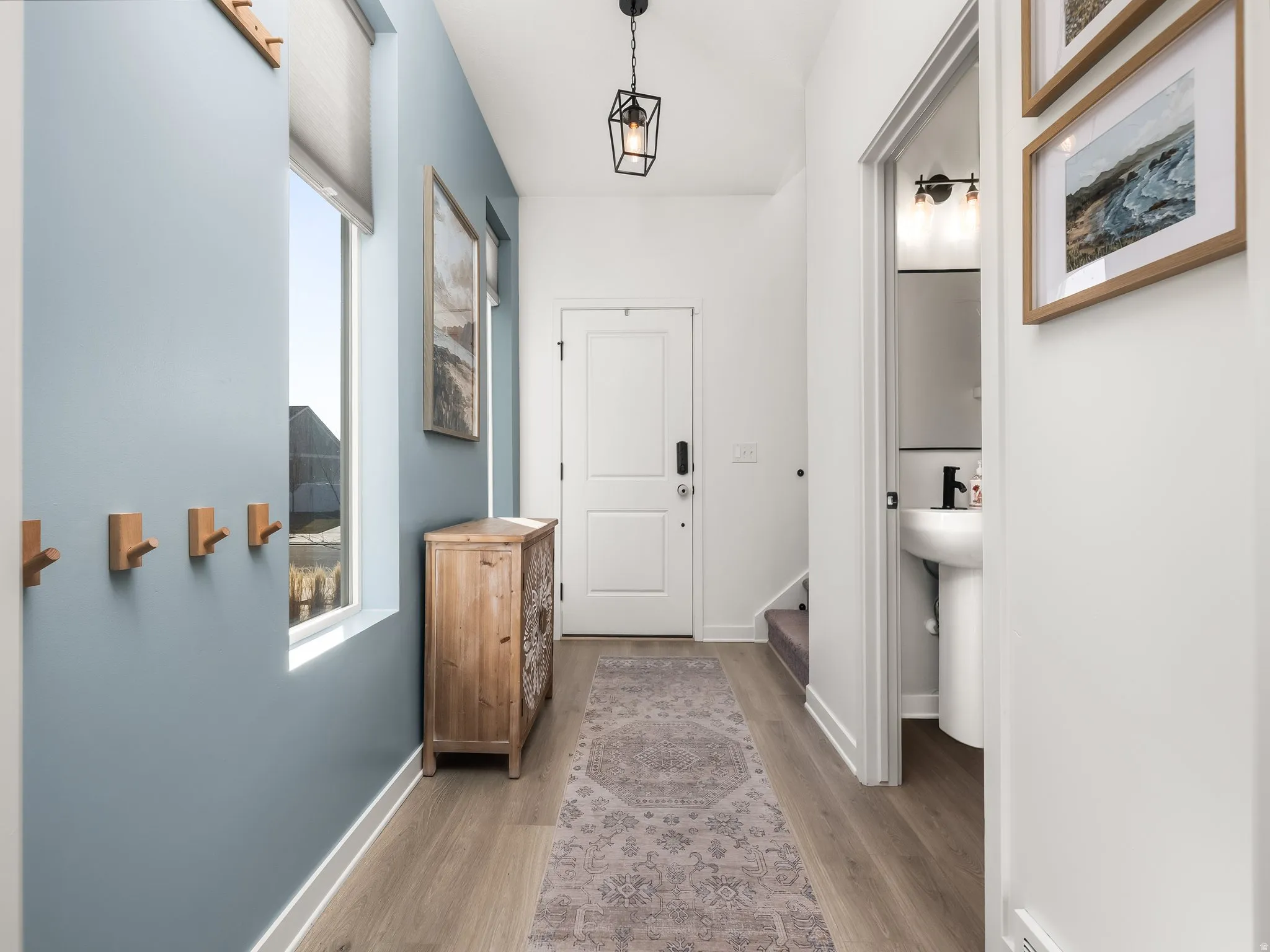 Hall with light wood-style flooring and baseboards