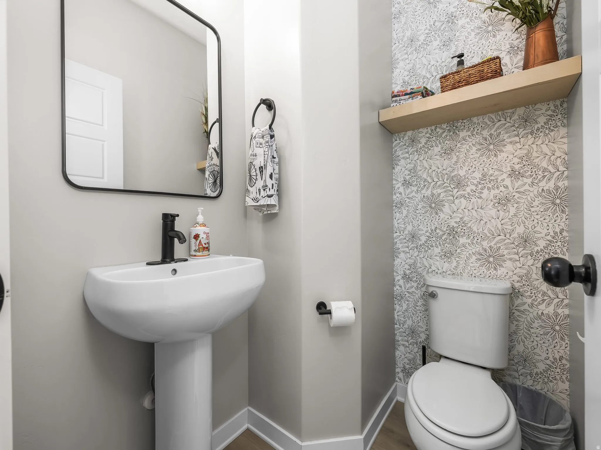 Half bath featuring toilet and wood finished floors