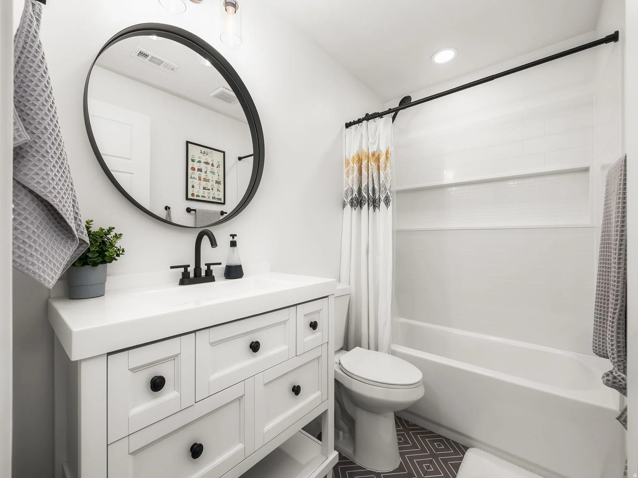 Bathroom featuring vanity, shower / bath combo with shower curtain, and recessed lighting